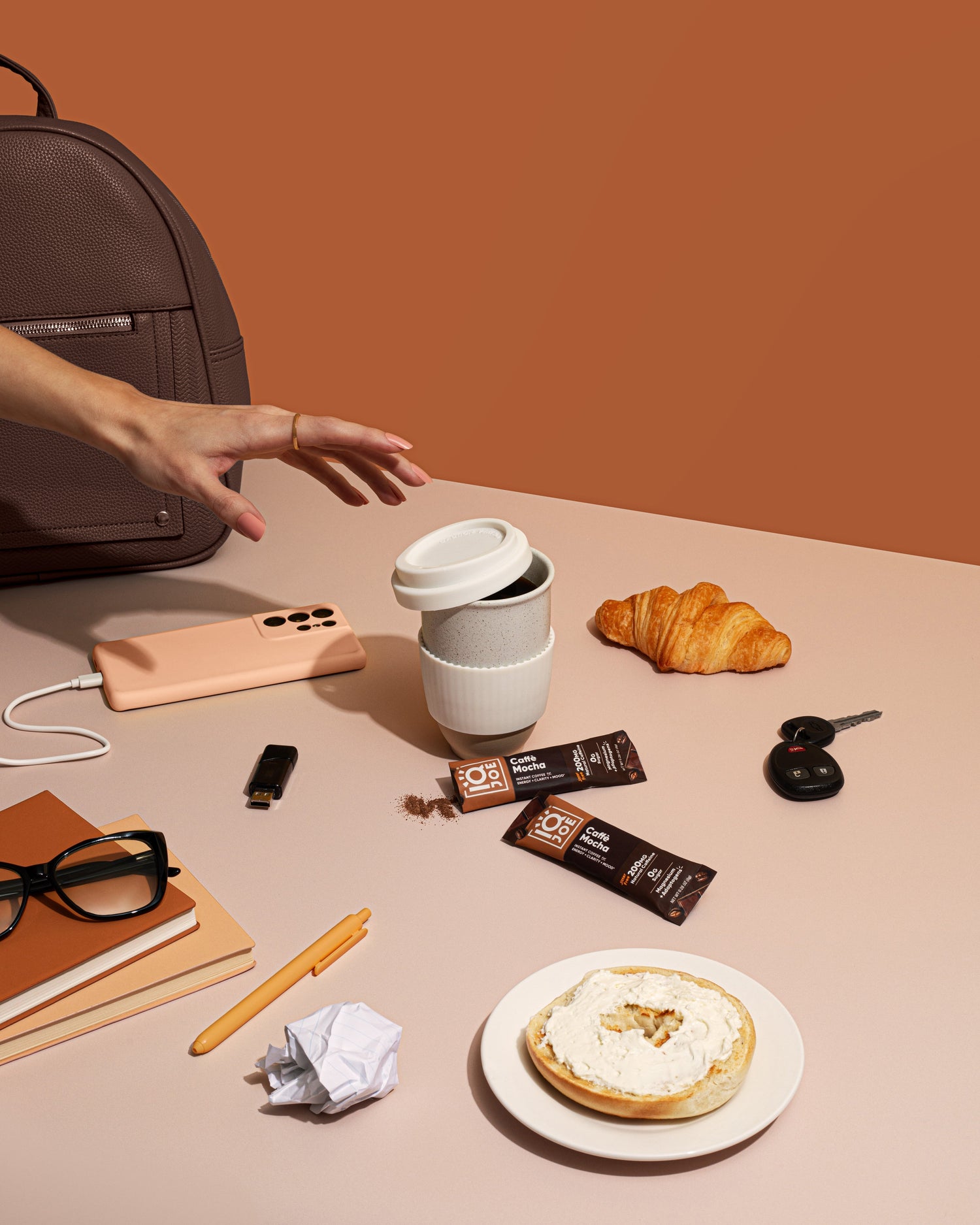 Caffe Mocha IQJOE in a to-go cup with breakfast and a backpack