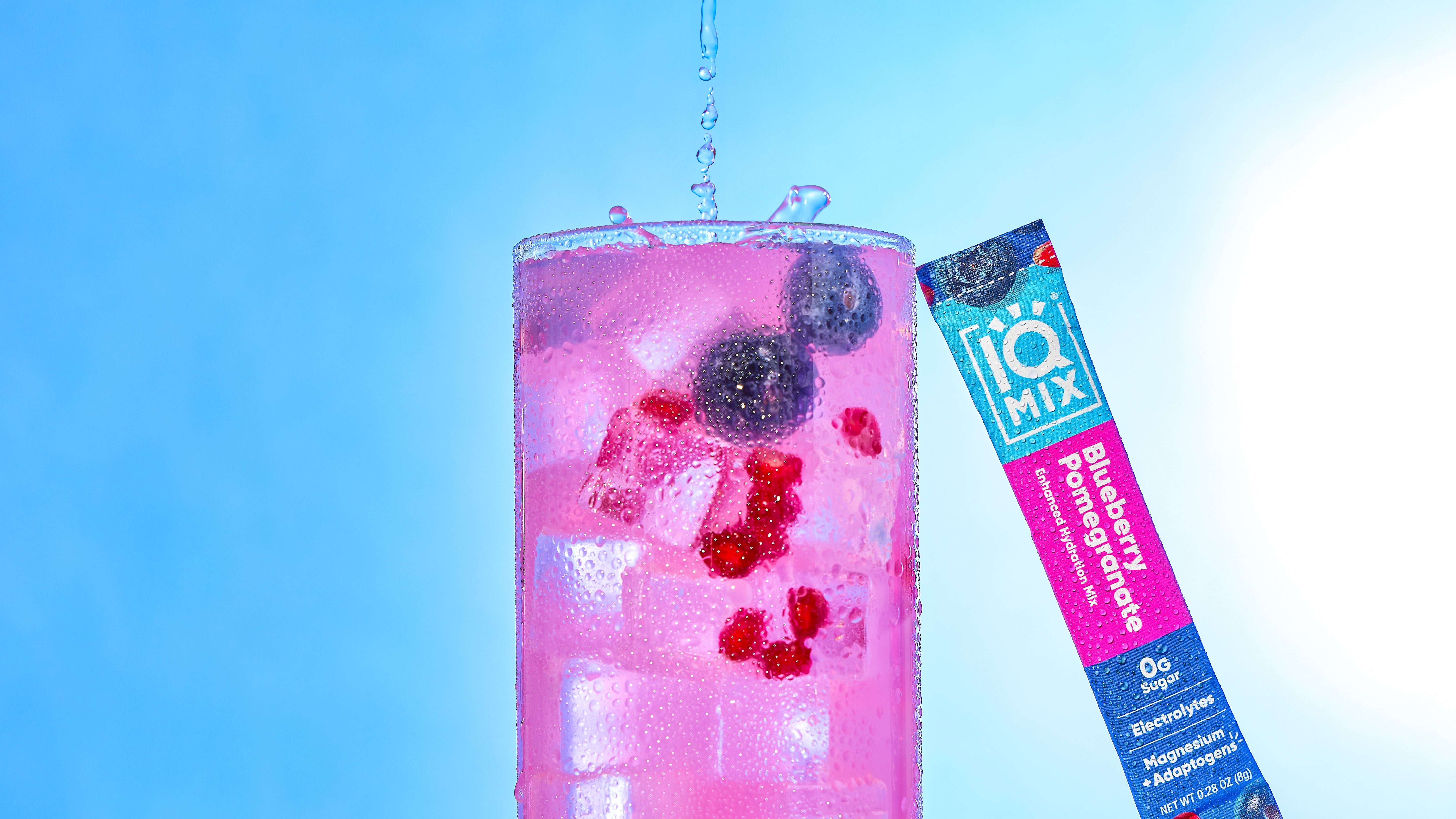 Blueberry Pomegranate IQMIX packet next to a glass of it