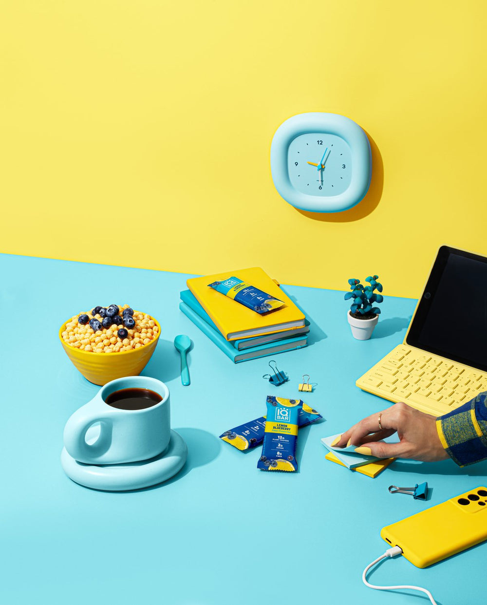 Desk with laptop, coffee, wall clock and IQBAR bars
