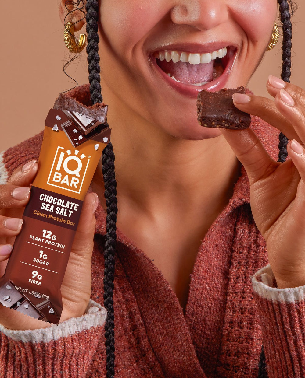 Woman biting an IQBAR Chocolate Sea Salt bar